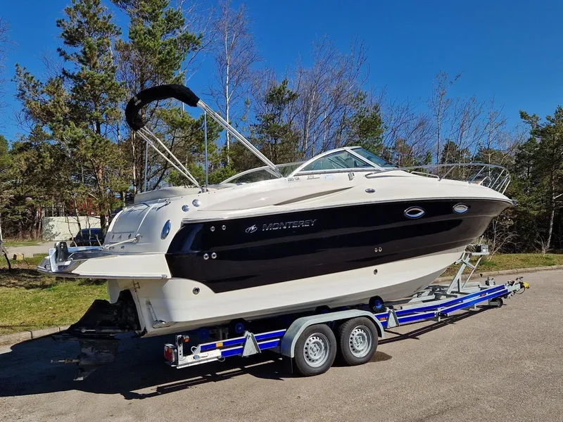 Slide: The Image of 2006 Monterey 270 Cruiser boat on trailer, parked outdoors with trees in the background. - 3