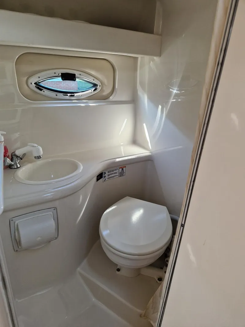 Slide: The Image of 2006 Monterey 270 Cruiser bathroom with sink, toilet, and porthole window. - 31