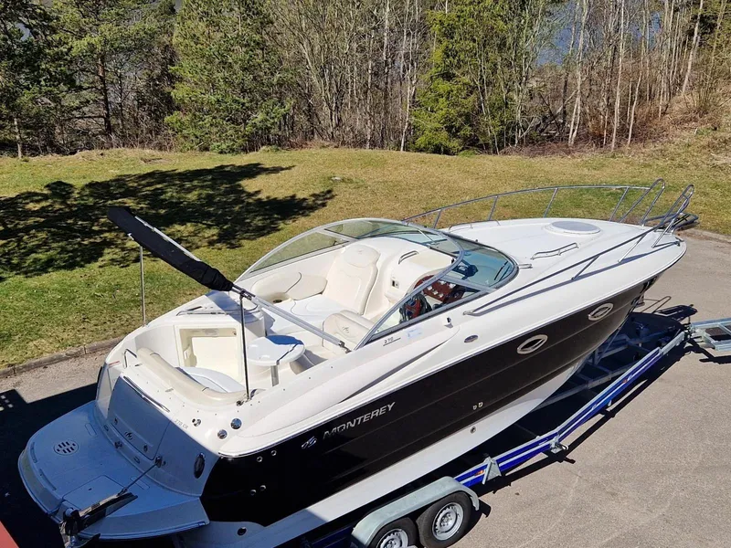 Slide: The Image of 2006 Monterey 270 Cruiser boat on trailer, surrounded by trees and grass. - 4
