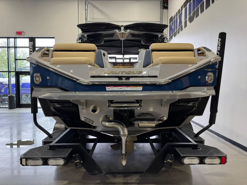 Slide: The Image of 2022 Nautique Super Air Nautique G23 Paragon boat displayed indoors, rear view. - 7