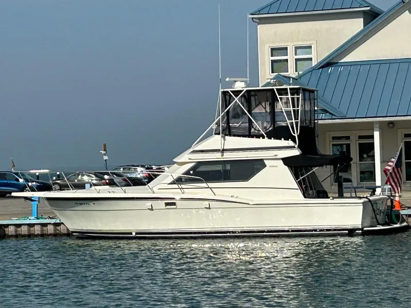 Slide: The Image of 1988 Hatteras 38 Convertible yacht docked beside a building with blue roof. - 1