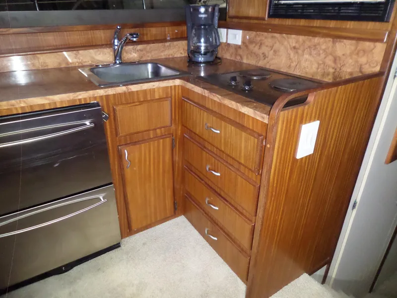 Slide: The Image of 1988 Hatteras 38 Convertible yacht kitchen with wood cabinetry, sink, and appliances. - 11