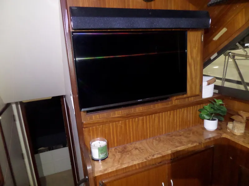Slide: The Image of Interior of 1988 Hatteras 38 Convertible with TV, candle, and plant on wooden cabinet. - 13