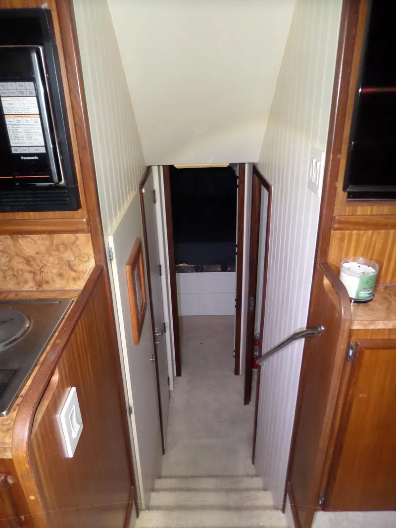 Slide: The Image of Interior view of 1988 Hatteras 38 Convertible yacht, featuring a narrow hallway and wooden cabinetry. - 14