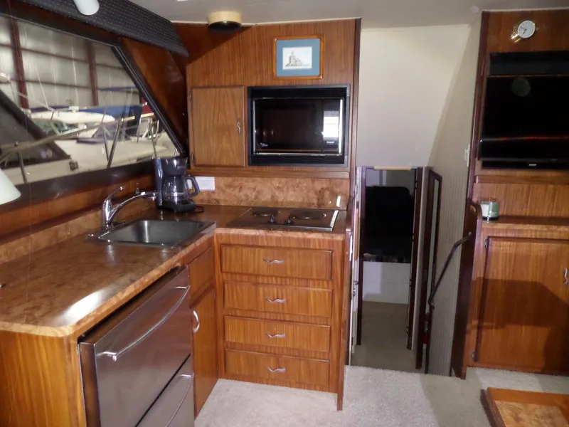 Slide: The Image of Interior of 1988 Hatteras 38 Convertible yacht kitchen with wood cabinetry and appliances. - 2