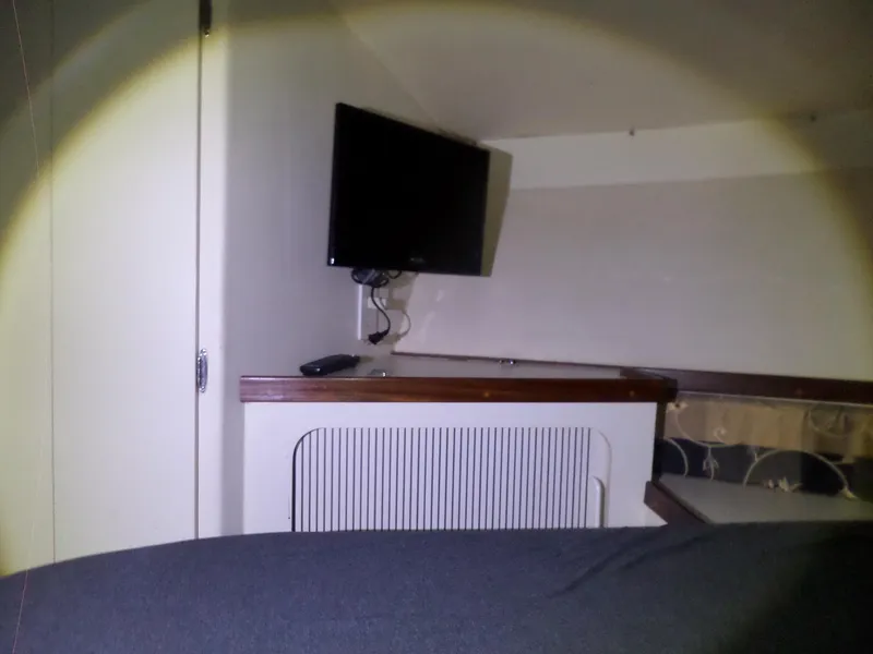 Slide: The Image of Interior of 1988 Hatteras 38 Convertible with mounted TV and wooden cabinetry. - 24