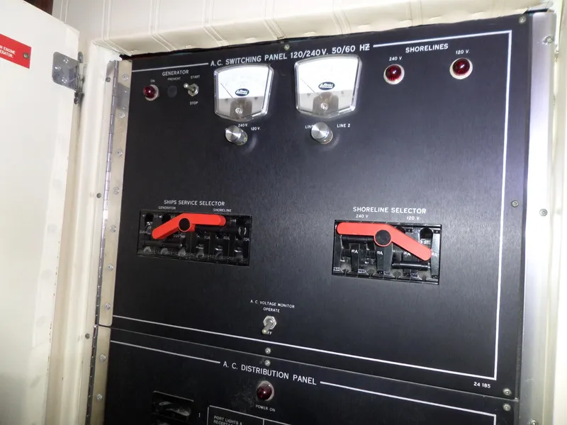 Slide: The Image of Electrical panel on 1988 Hatteras 38 Convertible boat, featuring AC switching and distribution controls. - 32