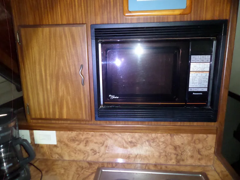Slide: The Image of 1988 Hatteras 38 Convertible kitchen with built-in Panasonic microwave and wooden cabinetry. - 37