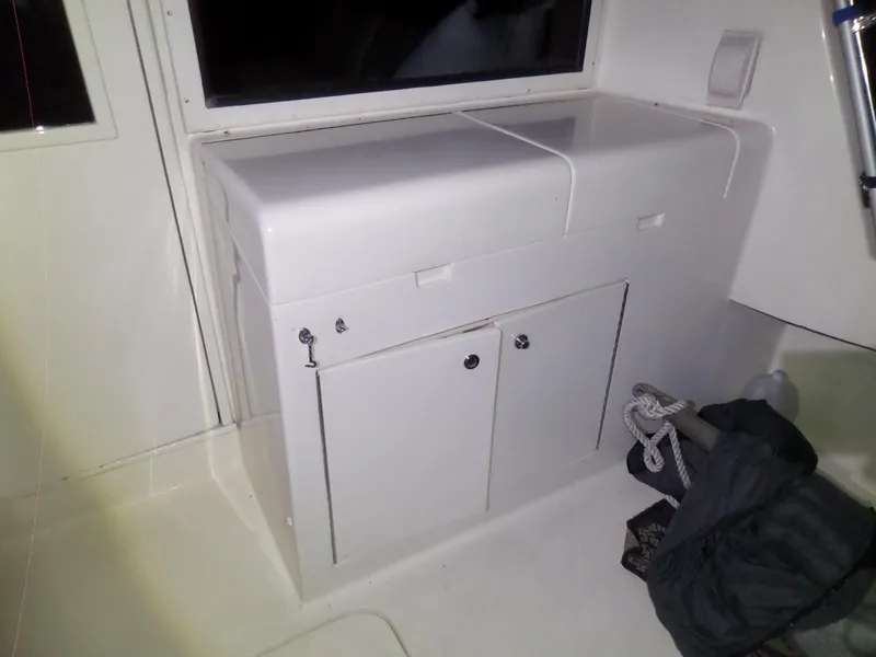 Slide: The Image of 1988 Hatteras 38 Convertible interior storage cabinet with closed compartments and nautical equipment. - 38