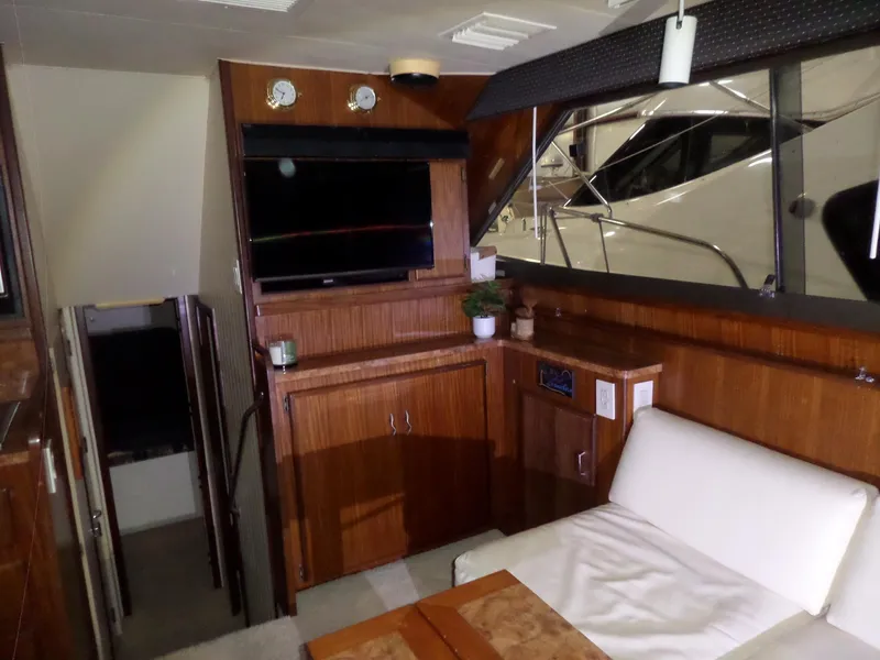 Slide: The Image of Interior of 1988 Hatteras 38 Convertible yacht with wood paneling and seating area. - 4