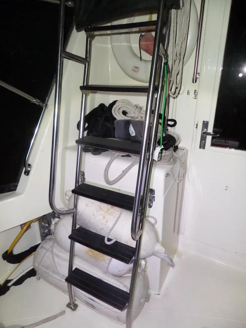 Slide: The Image of Stainless steel ladder on 1988 Hatteras 38 Convertible boat with ropes and life preserver. - 41