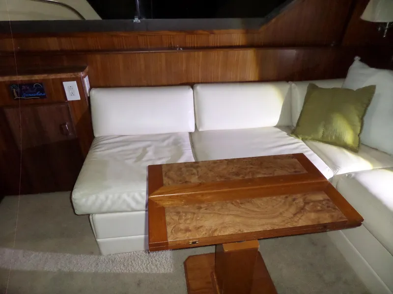 Slide: The Image of Interior of 1988 Hatteras 38 Convertible with white seating and wooden table. - 5