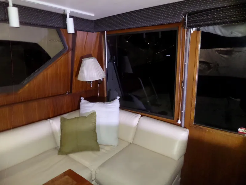Slide: The Image of Interior of 1988 Hatteras 38 Convertible yacht with white seating and wooden paneling. - 6