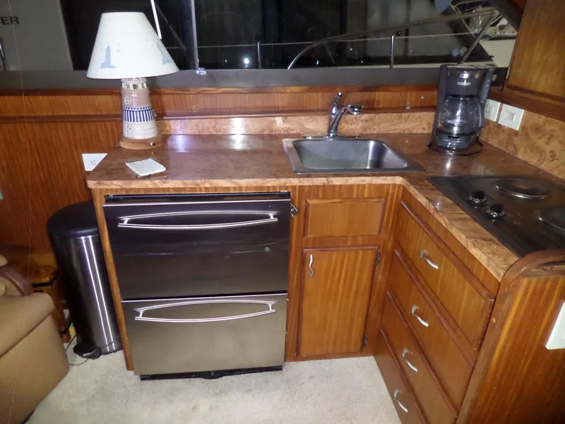 Slide: The Image of 1988 Hatteras 38 Convertible yacht kitchen with sink, stove, and stainless steel appliances. - 9
