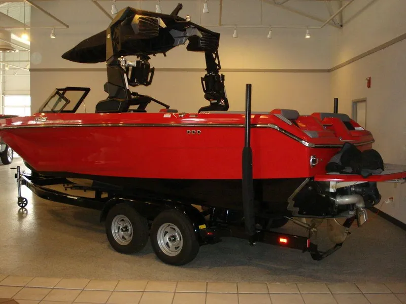 Slide: The Image of 2023 Nautique Super Air Nautique GS22 boat, red, on trailer, indoor showroom. - 3