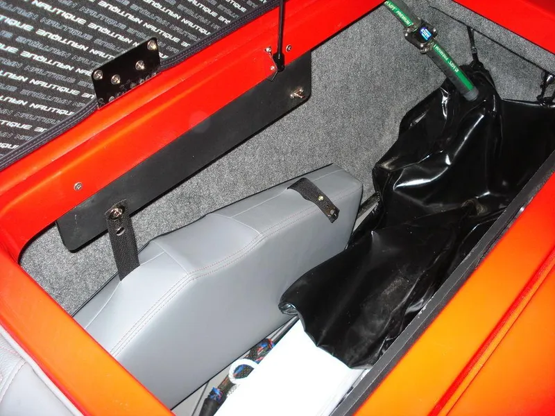 Slide: The Image of 2023 Nautique Super Air Nautique GS22 storage compartment with gray upholstery and black cover. - 9