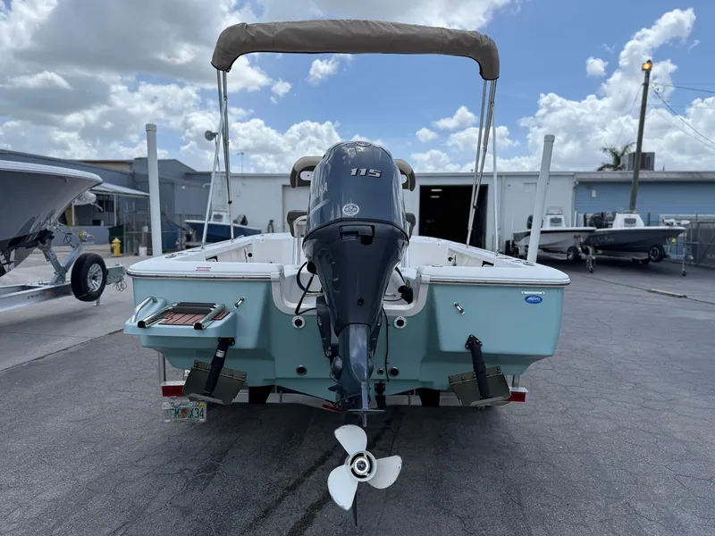 Slide: The Image of 2022 Tidewater 1910 Bay Max boat with outboard motor, parked outdoors under cloudy sky. - 10