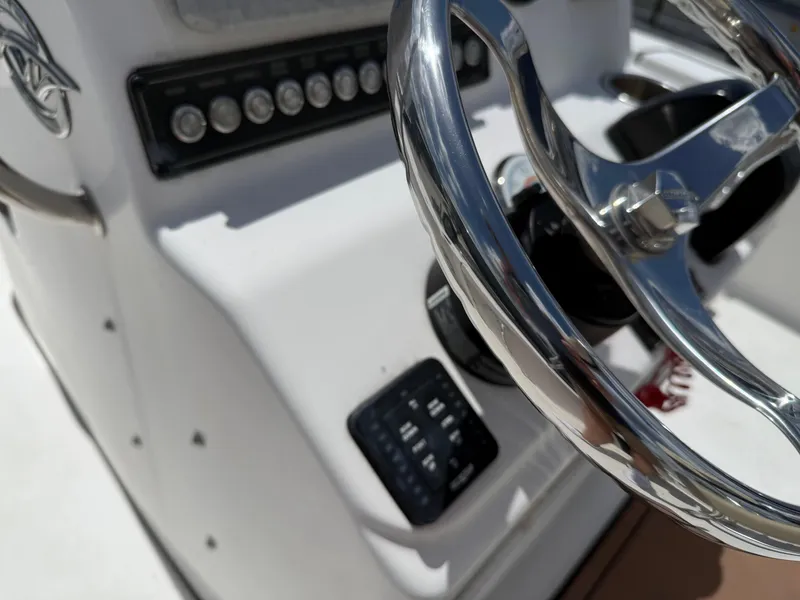 Slide: The Image of Steering console of 2022 Tidewater 1910 Bay Max boat with chrome wheel and control panel. - 16
