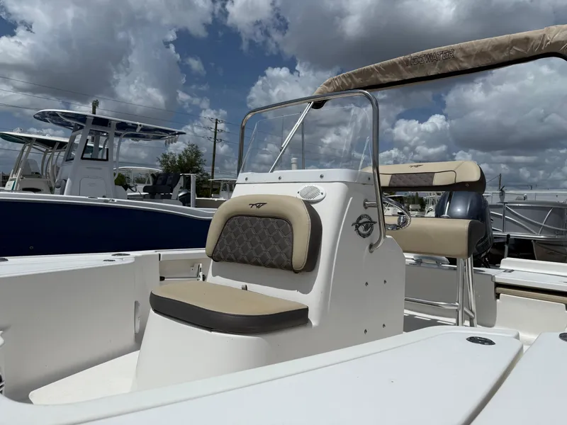 Slide: The Image of 2022 Tidewater 1910 Bay Max boat with beige seating under a cloudy sky. - 3