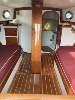 Slide: The Image of Interior of 2000 Hank Hinckley Great Harbor 26 Sloop with wooden finish and red cushions. - 14