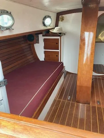 Slide: The Image of Interior of 2000 Hank Hinckley Great Harbor 26 Sloop with wooden finish and maroon seating. - 15