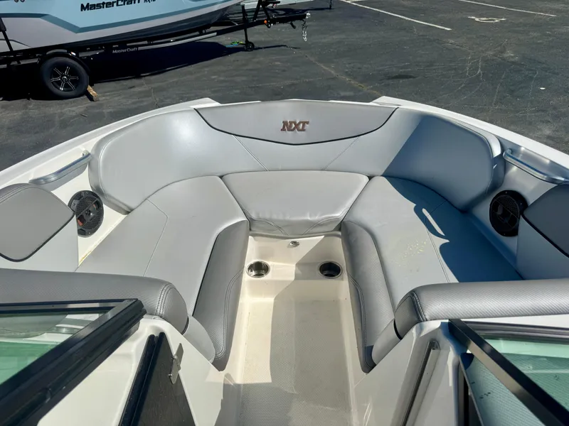 Slide: The Image of 2018 MasterCraft NXT22 boat interior with gray seating and cup holders. - 7