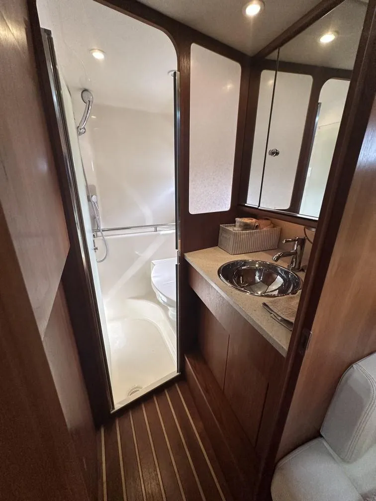 Slide: The Image of 2008 Tiara Yachts 3500 Sovran bathroom with shower, sink, and wooden accents. - 15