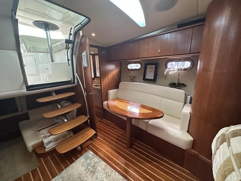 Slide: The Image of 2008 Tiara Yachts 3500 Sovran interior with wooden flooring, cozy seating, and elegant design. - 18
