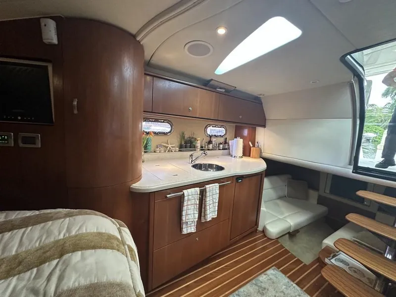 Slide: The Image of 2008 Tiara Yachts 3500 Sovran interior with kitchenette, wooden cabinetry, and cozy seating area. - 21