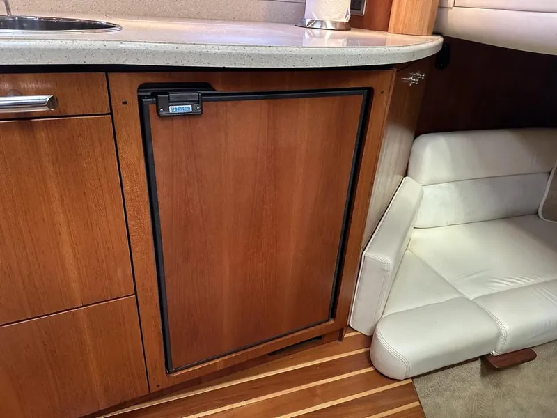 Slide: The Image of 2008 Tiara Yachts 3500 Sovran interior with wooden cabinetry and compact seating area. - 23