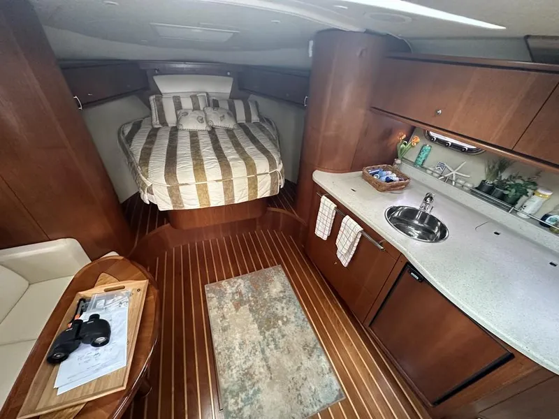 Slide: The Image of 2008 Tiara Yachts 3500 Sovran interior with bed, kitchenette, and wooden flooring. - 29