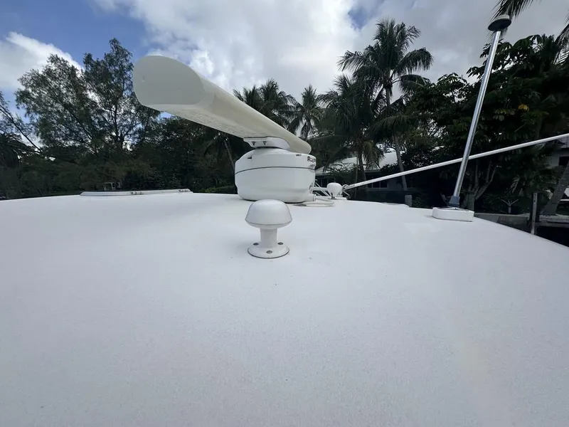 Slide: The Image of 2008 Tiara Yachts 3500 Sovran deck with radar, surrounded by trees and cloudy sky. - 33