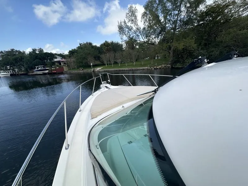 Slide: The Image of 2008 Tiara Yachts 3500 Sovran on calm water, surrounded by trees and boats. - 34