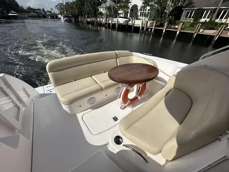 Slide: The Image of 2008 Tiara Yachts 3500 Sovran cockpit with beige seating and wooden table on a sunny day. - 7