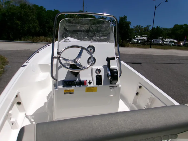Slide: The Image of 2025 Key West 1720 boat console with steering wheel and controls, parked outdoors. - 13