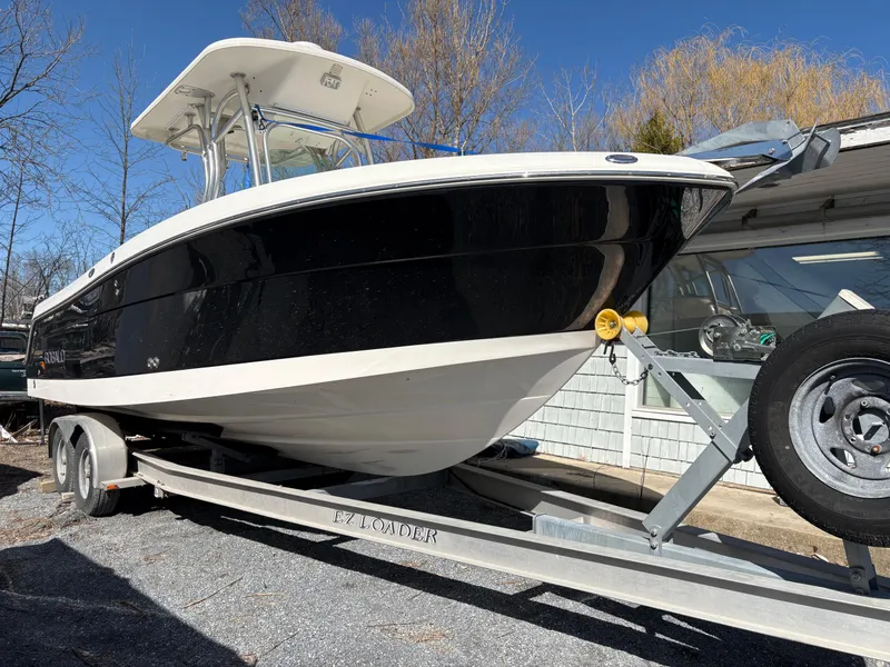 Slide: The Image of 2007 Robalo R240 Center Console boat on trailer, black and white design, parked outdoors. - 4