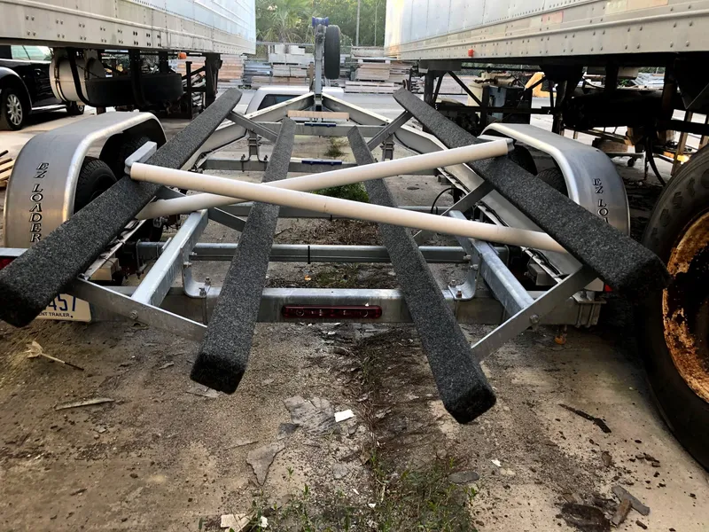 Slide: The Image of Trailer for 2007 Robalo R240 Center Console boat, parked between trucks. - 9