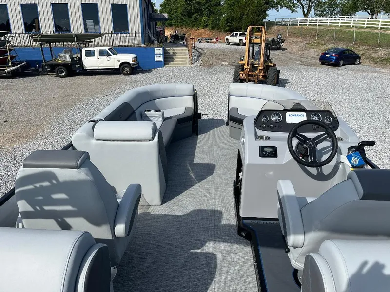 Slide: The Image of 2025 Veranda VS22RC pontoon boat with spacious seating and modern helm, parked on gravel. - 10