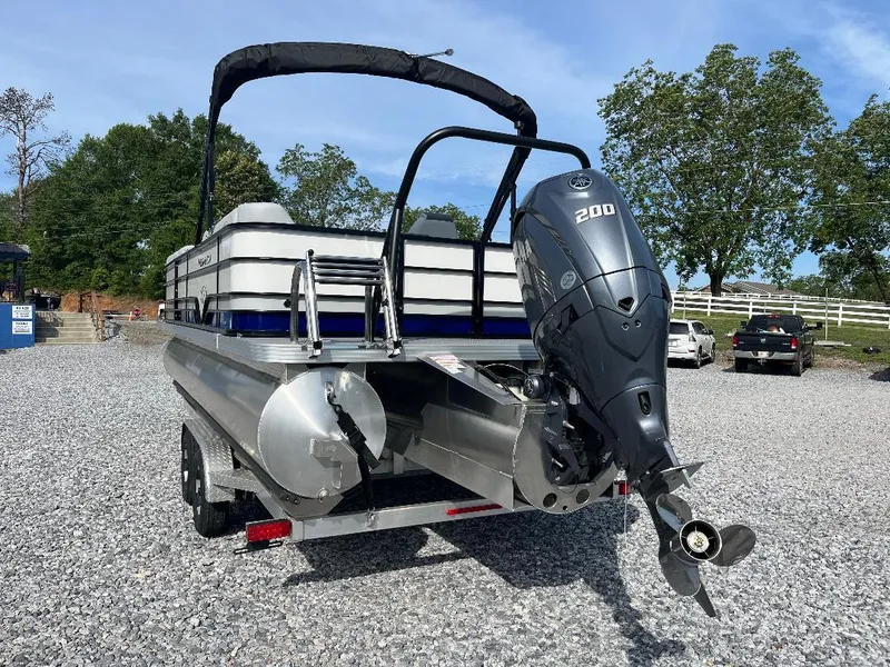 Slide: The Image of 2025 Veranda VS22RC pontoon boat with powerful outboard motor on gravel lot. - 2