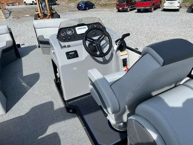 Slide: The Image of 2025 Veranda VS22RC boat interior with steering console and seating on gravel lot. - 9