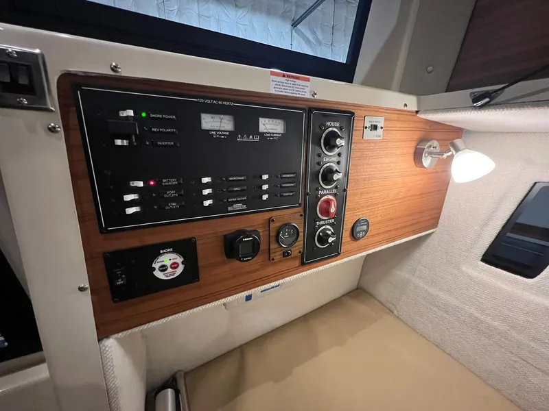 Slide: The Image of Control panel of 2023 Ranger Tugs R-25 boat with wood finish and modern switches. - 10