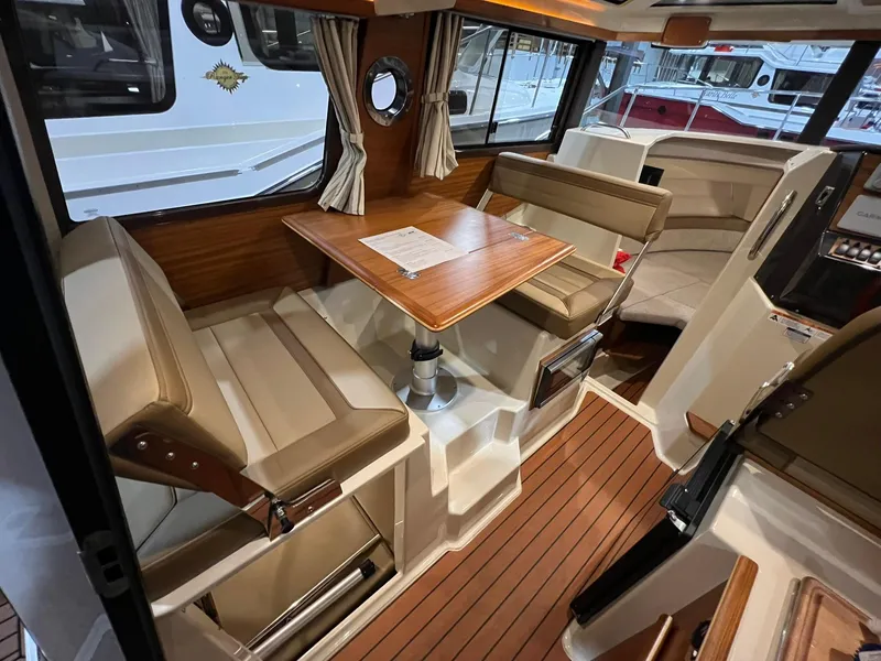 Slide: The Image of 2023 Ranger Tugs R-25 interior with wood accents and seating area. - 15