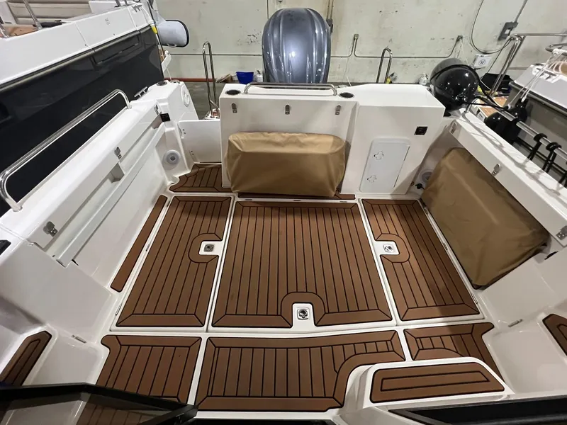 Slide: The Image of 2023 Ranger Tugs R-25 boat deck with wood-style flooring and storage compartments. - 7
