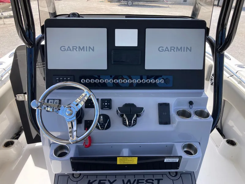 Slide: The Image of 2025 Key West 291FS boat dashboard with dual Garmin displays and steering wheel. - 10