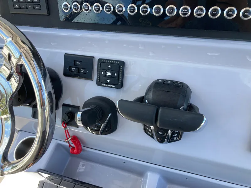 Slide: The Image of Control panel of 2025 Key West 291FS boat with steering wheel and throttle controls. - 11