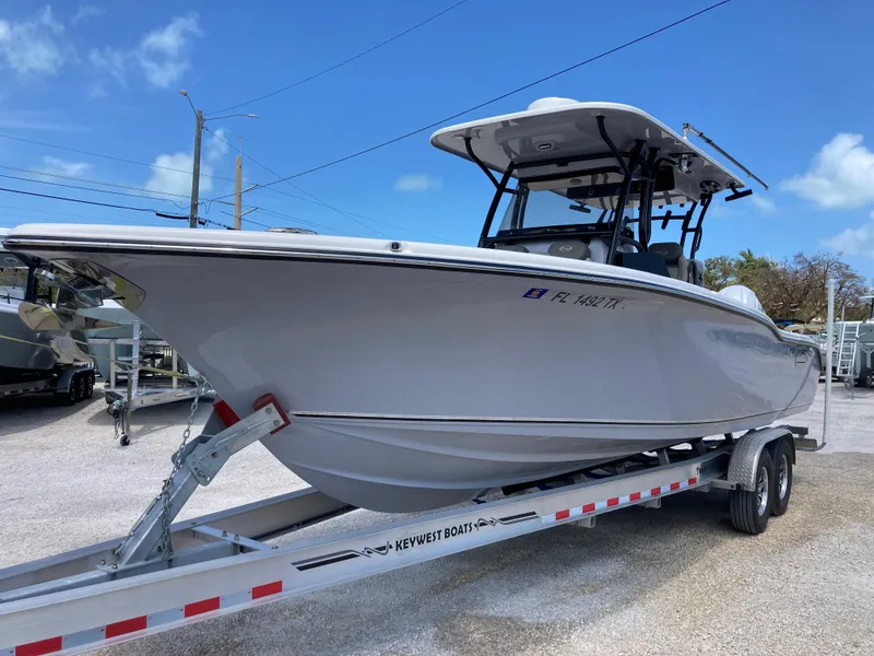 Slide: The Image of 2025 Key West 291FS boat on trailer under clear blue sky. - 6