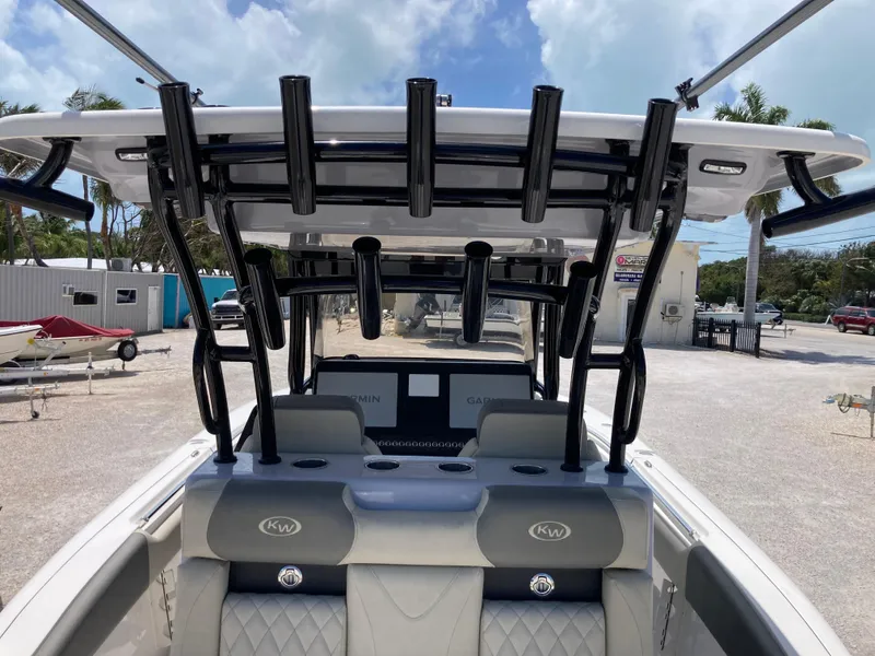 Slide: The Image of 2025 Key West 291FS boat interior with rod holders and seating, under a clear sky. - 8