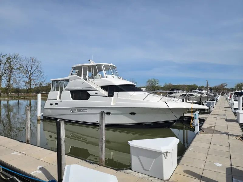 Slide: The Image of 2001 Silverton 453 Motor Yacht docked at a marina under clear skies. - 0