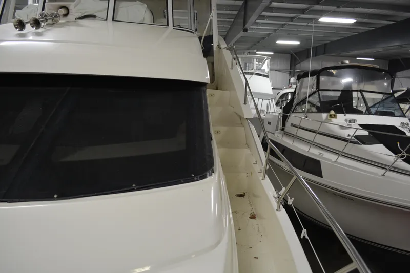 Slide: The Image of 2001 Silverton 453 Motor Yacht in indoor marina, showcasing sleek design and spacious deck. - 15