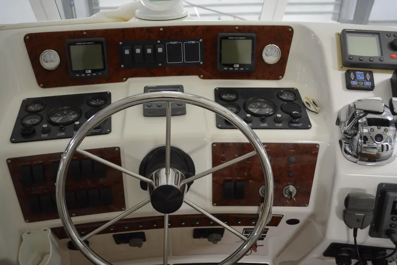 Slide: The Image of 2001 Silverton 453 Motor Yacht helm with steering wheel and control panels. - 18
